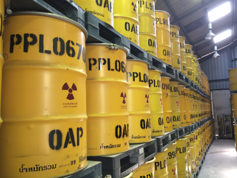 Three layers of yellow radioactive waste vessels sit in a row in a storage unit