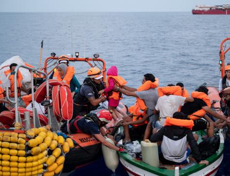 A group of workers from SOS Méditerranée transfer migrants from one boat to another in a search and rescue operation in the Mediterranean Sea. 