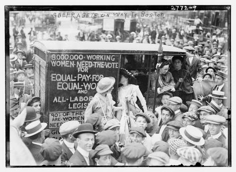 Black and white photograph of the Suffragettes on their way to Boston. They surrounded by a huge crowd of supporters