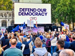 Defend our Democracy rally - view from the back where many people hold signs about democracy