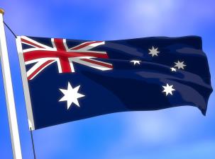 Austrlaian flag flies in the wind infrot of a blue sky