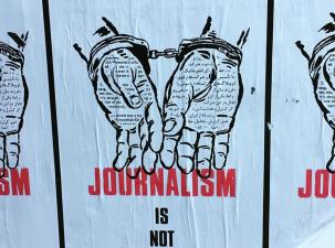 Drawing of handcuffed hands with the caption "journalism is not a crime".