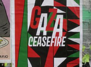 Gaza Ceasefire Poster. Gaza Ceasefire is written in white in the centre and all around are abstract triangles in the colours of the Palestinian flag.