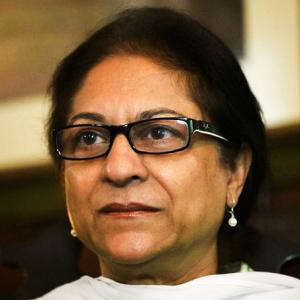 Close up head shot of a Pakistani woman wearing a white scarf and glasses