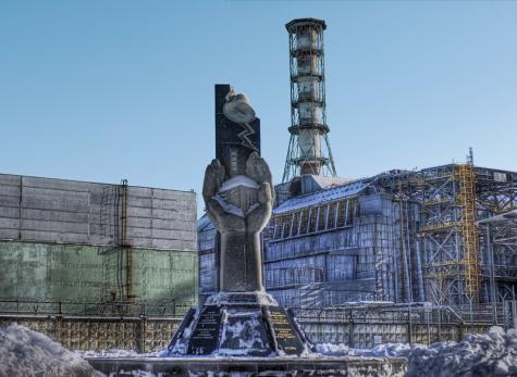 Image of the Chernobyl nuclear power plant facility that was destroyed in a nuclear disaster. There is snow on the ground and a rusted tower looms in the background