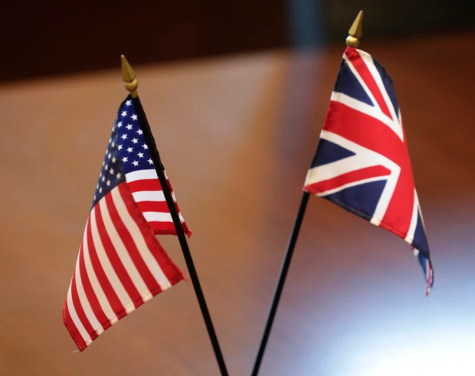 Two small flags sit side-by- side. One the left is the U.S. flag and on the right the Union Jack