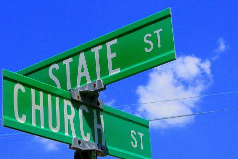 Two green metal road signs are attatched to a pole under a blue sky. The intersection is Church Street and State Street