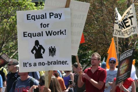 US protesters gather in the streets fighting for equal pay and to close the wage gap. Protesters hold signs which say 'Equal pay for equal work'