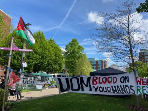 Banners hang at the entrance to the University of Manchester Gaza protest encampment. The signs read ‘UOM blood on your hands’ and ‘University of Manchester UCU for Palestine’. 