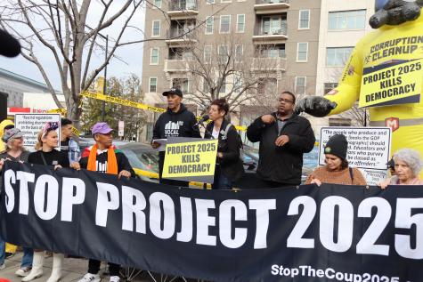 Protesters rally infront of the Heritage Foundation building in Washington DC. The hold a large black banner that says 'Stop Project 2025'