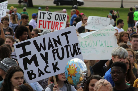 Young people gather at a climate strike rally where they hold banners which read 'I want my future back' and 'It's our future'