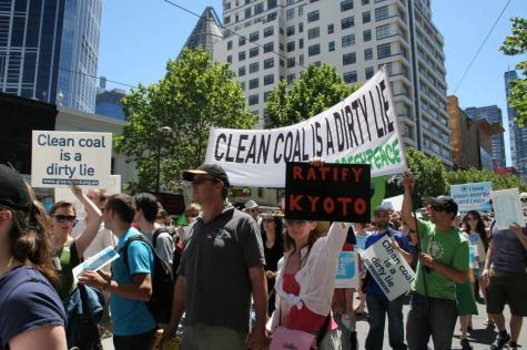 Protesters line the streets to campaign against Big Coal. The is a large banner that says 'Clean Coal is a Dirty Lie'