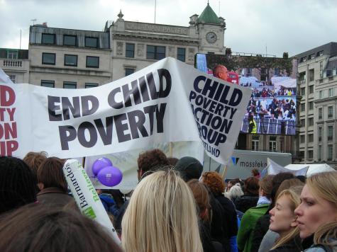 Protests line the streets rallying to end child poverty. There are many banners and balloons.