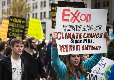 A protester holding a sign about the climate change denial of ExxonMobil at the protest Our Generation, Our Choice in Washington, D.C.